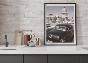 Architectural street photograph of a classic car beneath Havana’s domed El Capitolio.
