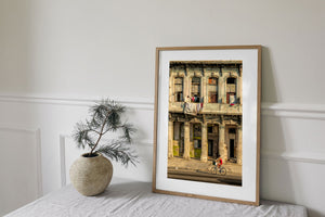 A cyclist rides past faded plaster walls and balcony laundry in Havana, Cuba.