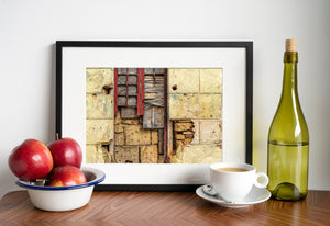 A weathered window with red trim and splintered boards set into a crumbling Havana wall.