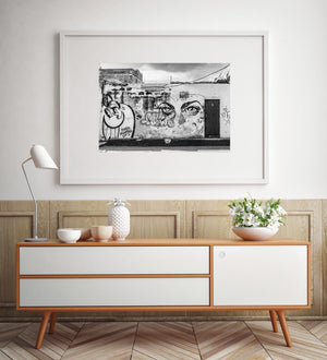 Black and white Havana photograph showing street art, wall textures and a wooden doorway.