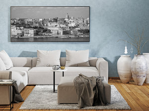 Black and white panorama of Havana rooftops and waterfront with El Capitolio in the distance.