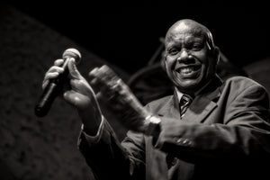 Close portrait of Cuban jazz vocalist holding microphone on stage