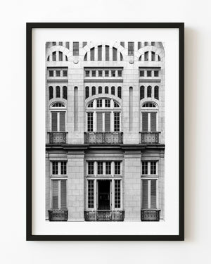 Symmetrical courtyard facade at Havana’s Revolution Museum with arched windows and balconies in black and white.