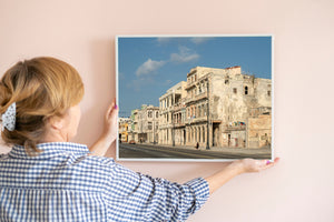 Havana waterfront street scene with old buildings, decorative lamps and pedestrians in warm sunlight.