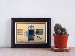 Yellow Havana storefront with blue grilles and a horse-and-carriage mural beside the entrance.