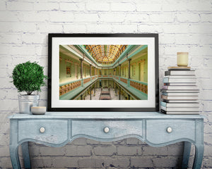 Green walls and ornate cream details frame the stained-glass roof at Hotel Raquel in Havana.