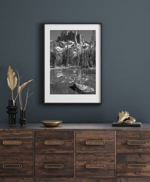 Black and white Howser Spire landscape with rugged peaks, alpine trees and still-water reflections.