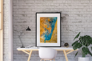 Blue mineral formations trace a curved channel through ochre earth in an Icelandic aerial photograph.