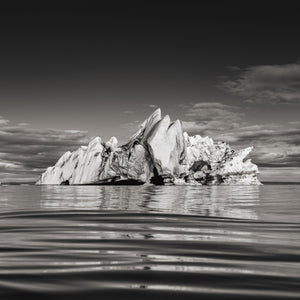 Jagged glacier iceberg reflected in calm Iceland water