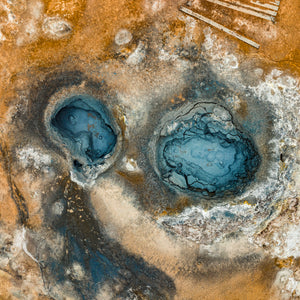 アイスランドの鉱物で汚れた地面に囲まれた地熱プールのドローン写真