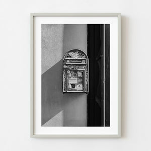 Graffiti covered mailbox mounted on Reykjavik wall in black and white