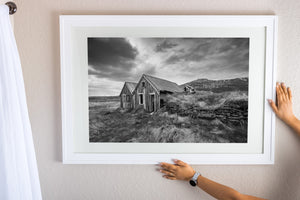 weathered wood Iceland farm building with stone wall foreground