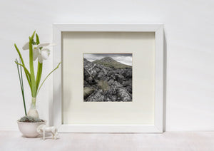Irish landscape with deeply weathered rock surfaces below a low, grass-covered hill.