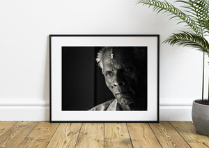 Elderly man looking toward the camera in dramatic side light