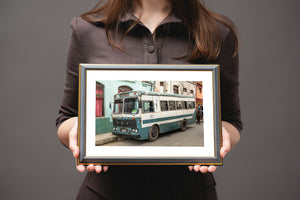 old Cuban transit bus parked beside faded buildings