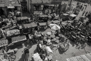 busy Indian street with fruit carts motorcycles and people