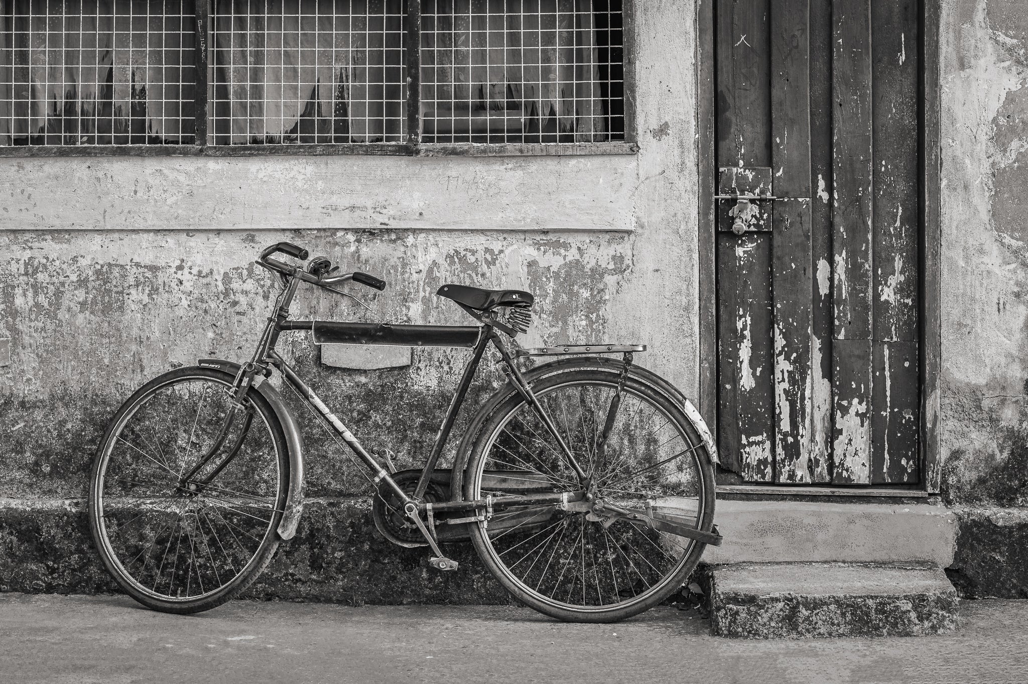 Vintage-Fahrrad gegen verwitterte Wand schwarz und weiß Wandkunst – Dan Kosmayer Fine Art Photography