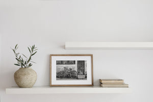 rusted bicycle against textured wall black and white photo