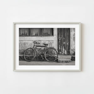 vintage bicycle leaning against weathered wall in black and white