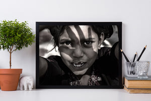 Close street portrait of a girl with raised arms, textured light and an open mouth.