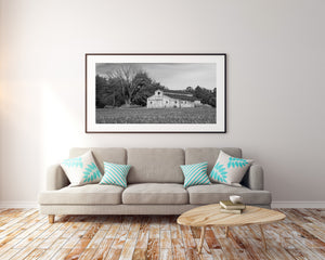 Black and white rural photograph of a long Indiana farm building and branching leafless tree.