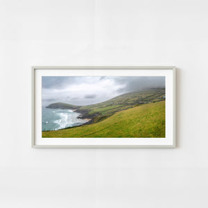 Dingle Peninsula coastal landscape with ocean waves and green fields