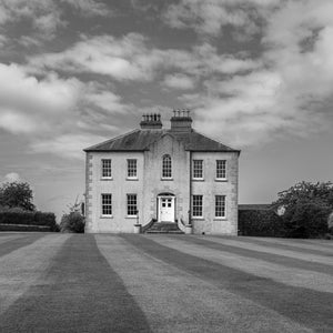 Symmetrical Irish country house beneath a clouded sky