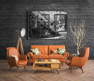 Architectural detail of metal stairs against a brick wall with posters