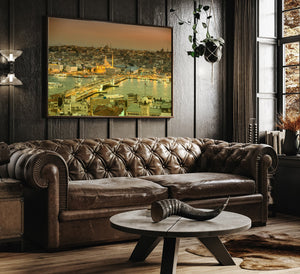Golden city lights reflect across the water beside Galata Bridge in Istanbul at dusk.