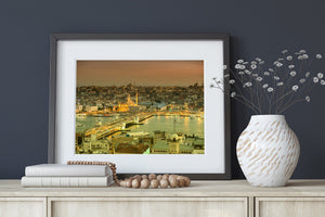 Boats and bridge traffic cross the foreground of an illuminated Istanbul waterfront cityscape.
