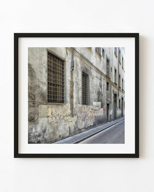 Weathered Italian facade with barred windows and peeling plaster