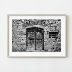 Old wooden doorway in Italian stone wall black and white