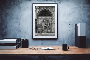 Monochrome street mural framed by aged plaster and archway