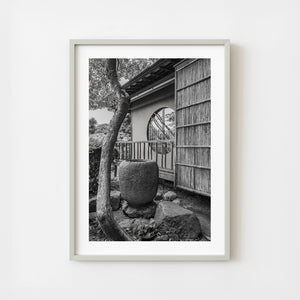Traditional Japanese garden stone water pot beside wooden building