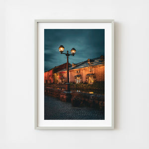 Otaru canal warehouses at night with glowing streetlamp