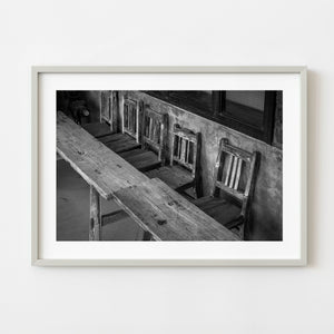 Black and white photograph of weathered wooden chairs in Japan