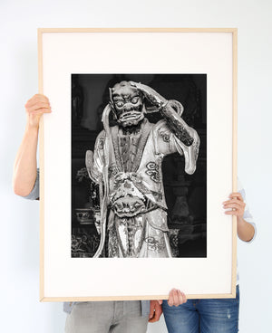 Historic guardian sculpture with cracked paint and carved robes