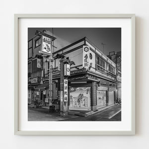 Black and white Tokyo street corner restaurant with traditional signage