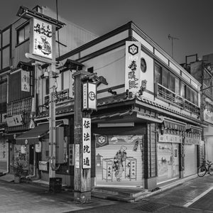 Asakusa Japan building corner with closed shutters and murals monochrome