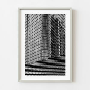 Traditional shrine roof below curved glass skyscraper in Tokyo black and white