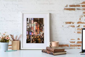 Shinjuku street photography with stacked neon signs and narrow buildings