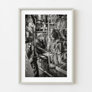elderly street vendor sitting in Tokyo market stall black and white