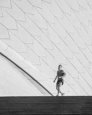 Man running above steps beside Sydney Opera House