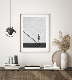 Sydney Opera House tile patterns towering above a lone jogger