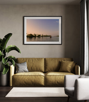 Soft orange sky above palm trees and rippling water