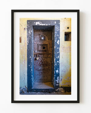 Kilmainham Gaol cell door with peeling paint and a blue frame