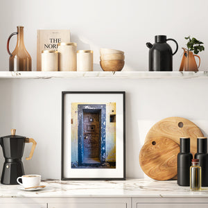 Blue doorway framing an aged locked wooden prison door