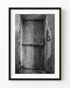 Locked cell door at Kilmainham Gaol in black and white