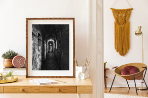 Light from windows falling across a narrow jail corridor
