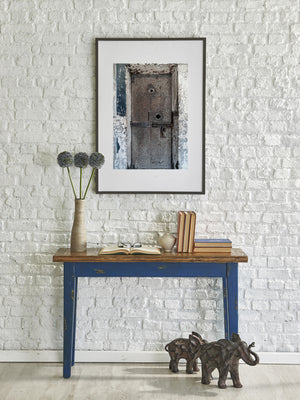 Historic prison doorway with flaking paint and rough wall textures